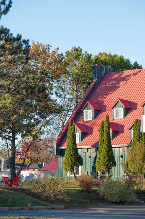A building with a red roof, green siding, and multiple windows. - Hotel Cowansville (Cowansville)