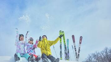 Un groupe de personnes est assis sur une pente enneigée, leurs skis étant alignés derrière eux.