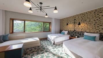A hotel room with two beds, a sofa, a large window, and a ceiling light fixture.