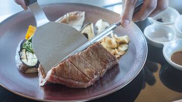 Una persona che taglia una bistecca su un piatto con una spatola.