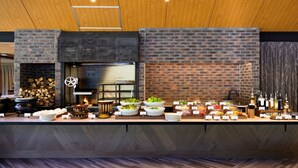 A buffet setup with a brick wall backdrop, a wood-paneled ceiling, and a variety of food and drink options. - Karuizawa Prince Hotel East (Karuizawa)