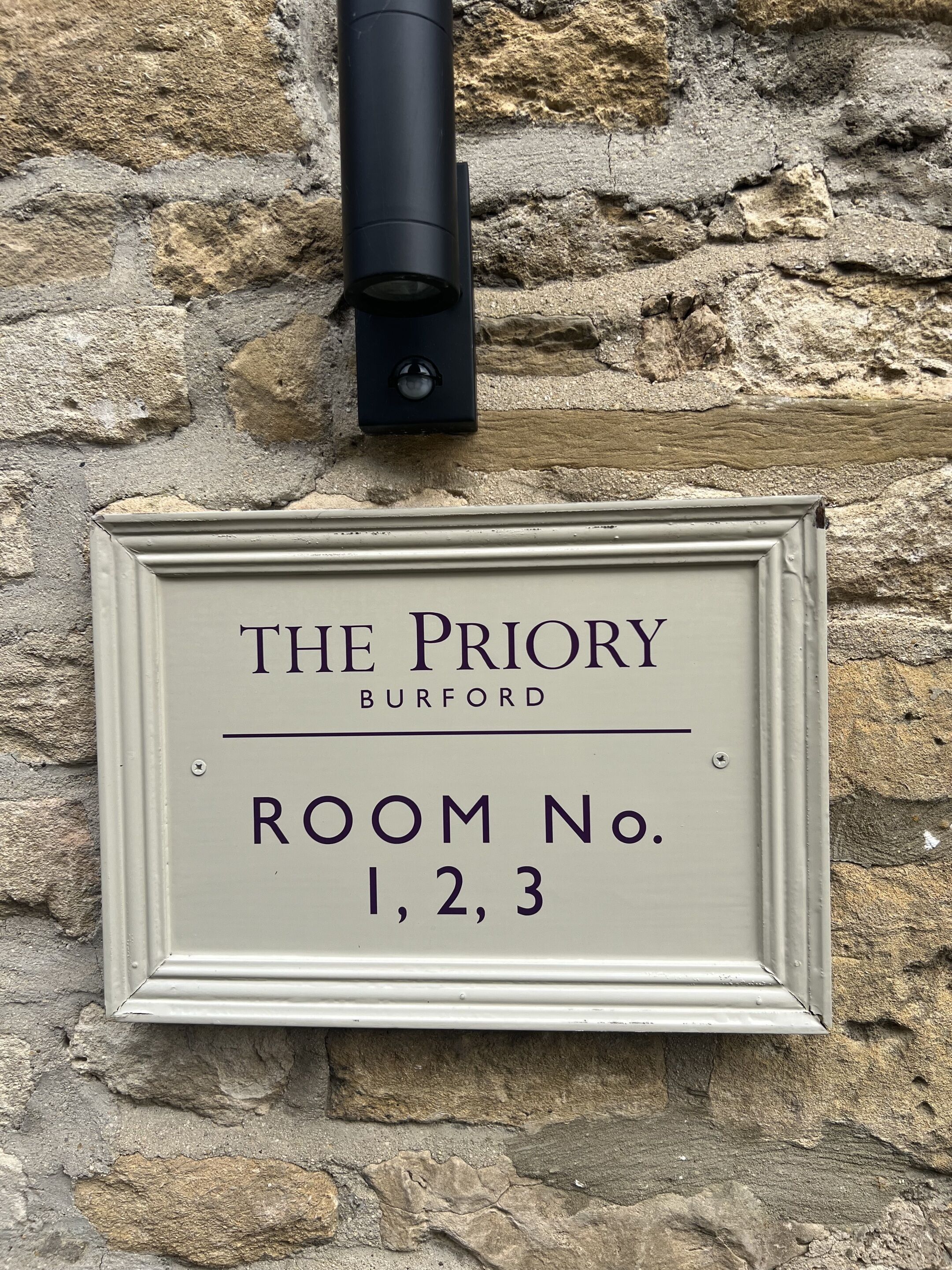 Een bordje voor 'The Priory' in Burford, waarop kamer nummers 1, 2 en 3 staan.
