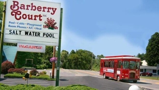 A sign for Barberry Court LLC advertising a saltwater pool, a playground, and other amenities.