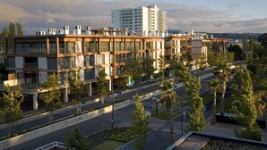 Ein modernes Gebäude mit mehreren Etagen, großen Fenstern und einem Flachdach.