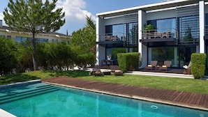 A modern house with a swimming pool, outdoor seating, and a well-maintained garden. - Troia Residence Beach Houses (Grandola)