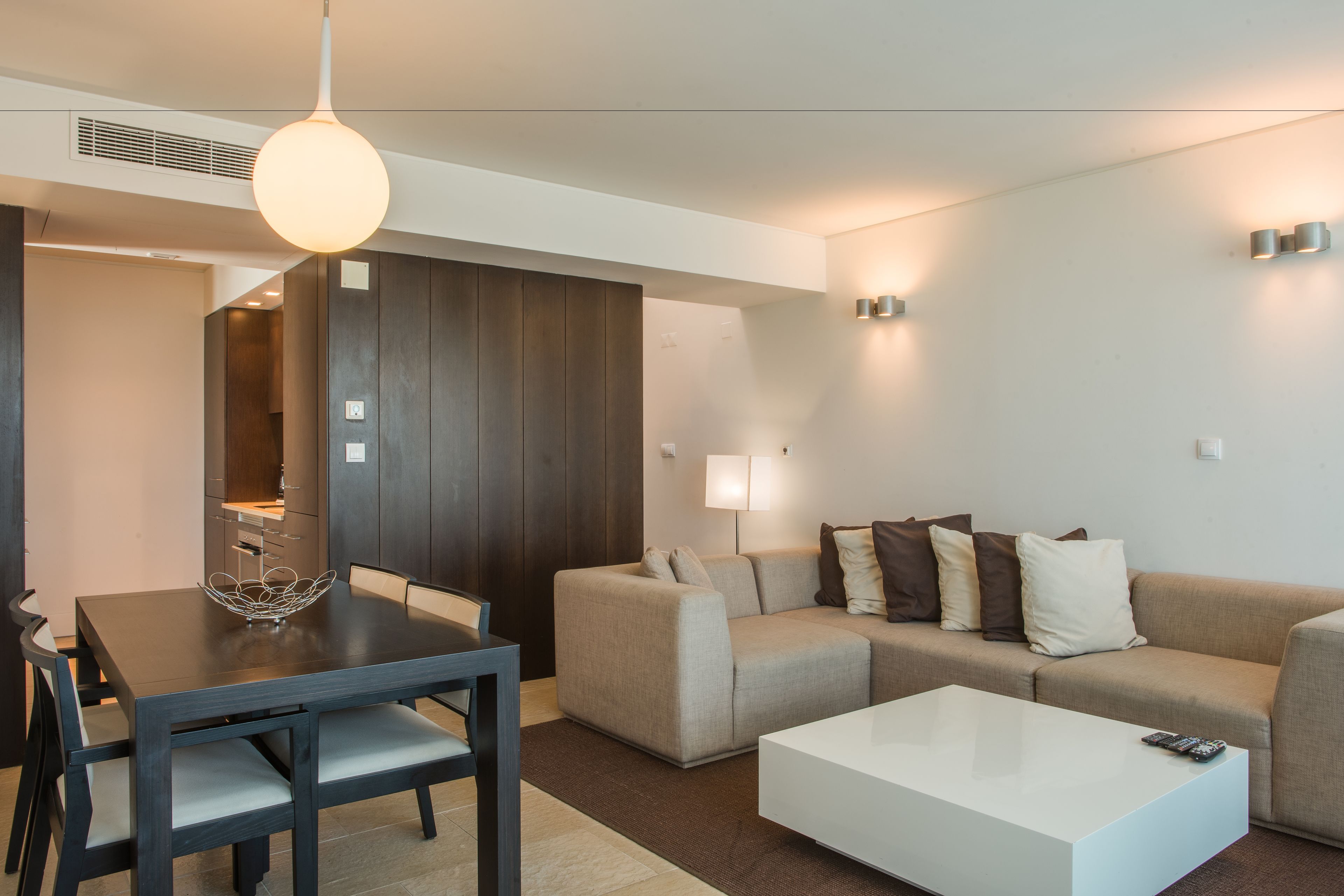 Un salon moderne avec une table à manger, un canapé et une table basse.