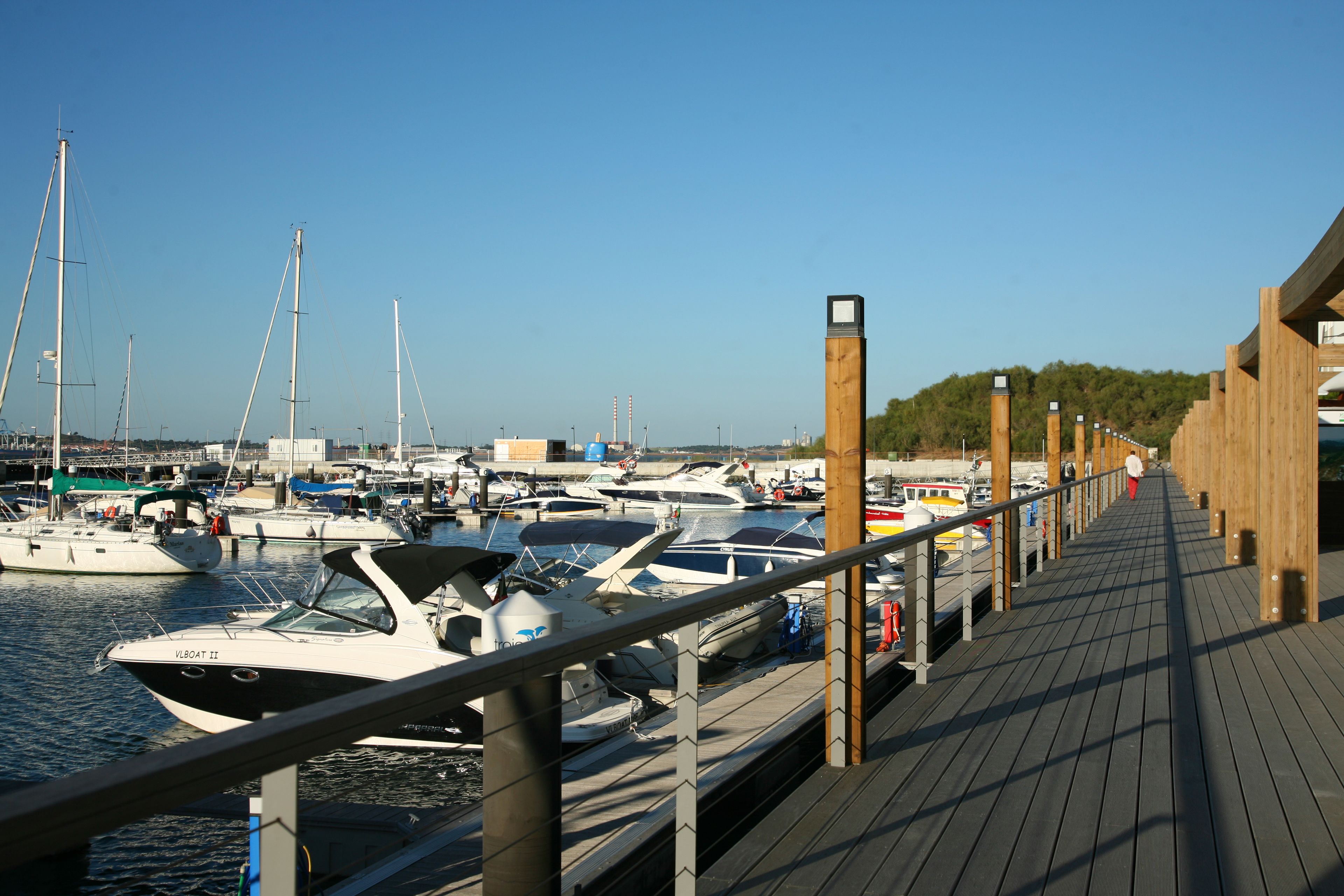 Un muelle de madera con barcos amarrados en un puerto deportivo.