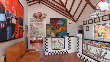 A reception area with a mosaic tile design, a wooden ceiling, and a large abstract painting on the wall.