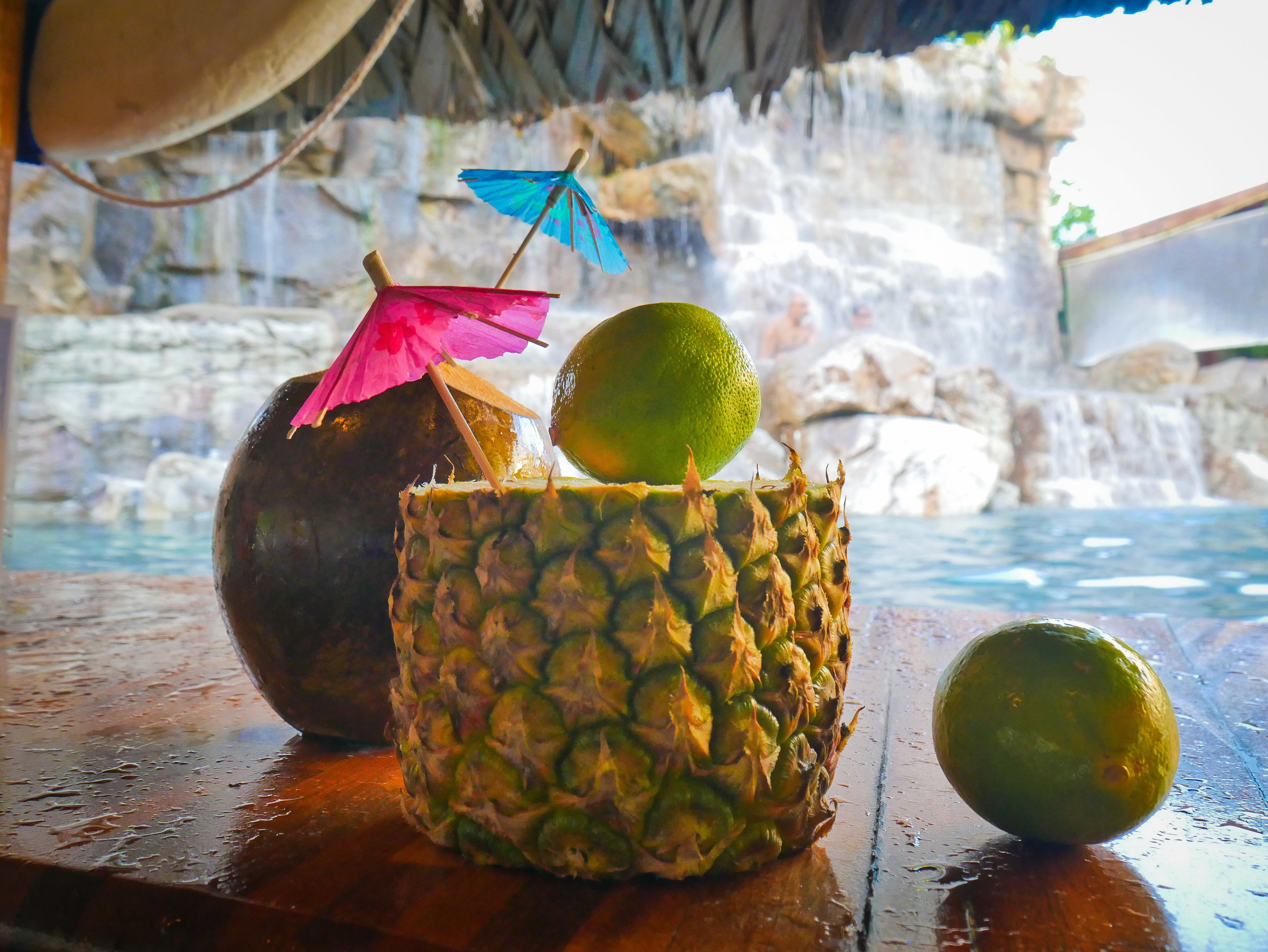Un décor tropical avec une table en bois, un ananas et un citron vert.