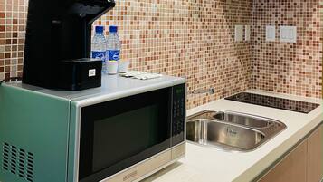 A kitchen with a microwave, a coffee maker, and a sink.