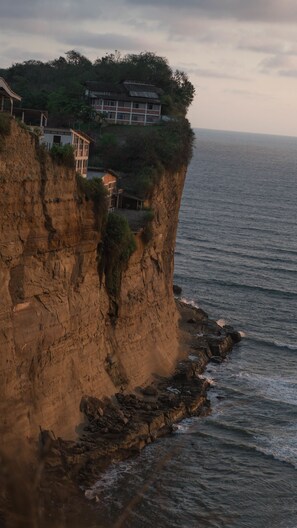 A coastal cliff with a building on top, overlooking the sea. - Ocean Blue Hotel (Manglaralto)