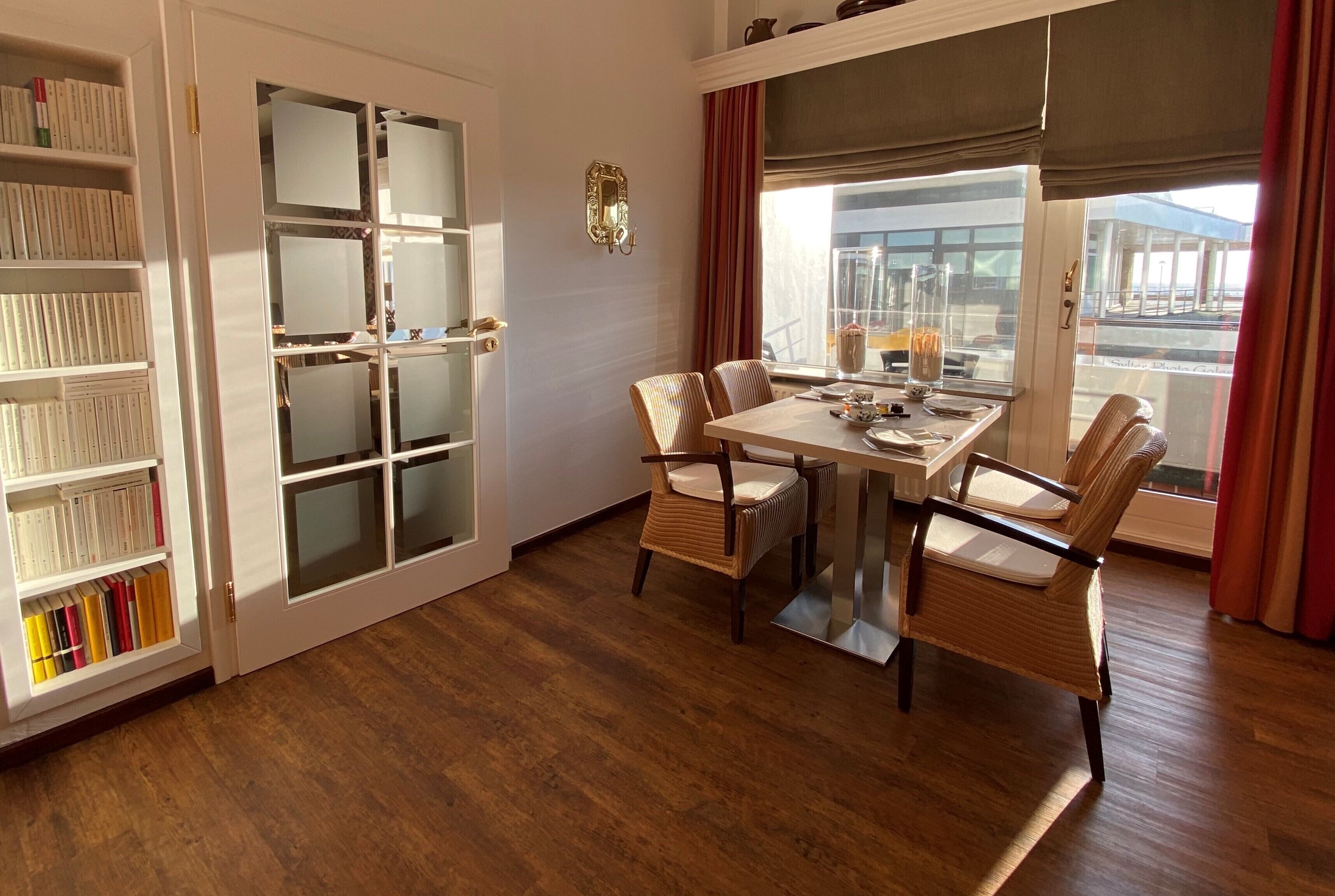 A dining area with a table, chairs, and a bookshelf.