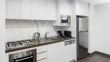 Una cocina moderna con armarios blancos, electrodomésticos de acero inoxidable y salpicadero de mármol.