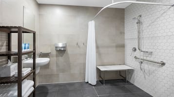 Un bagno moderno con doccia, lavandino e sedile.