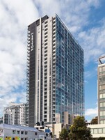 Un hôtel de grande hauteur au design moderne, caractérisé par une enseigne verticale bien visible sur sa façade.