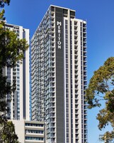 A tall, modern hotel building with the name 'MERITON' prominently displayed on its facade.