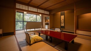 Una habitación tradicional japonesa con esteras de tatami, una mesa baja de tatami y un sofá.