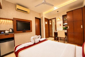 A hotel room with a bed, a TV, a desk, and a dining area. - The Altruist Andheri Hotel (Mumbai)