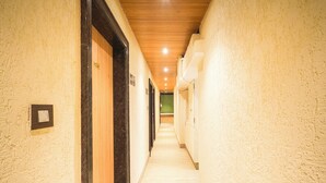 Un passadís llarg i estret amb portes de fusta i parets de tons clars.