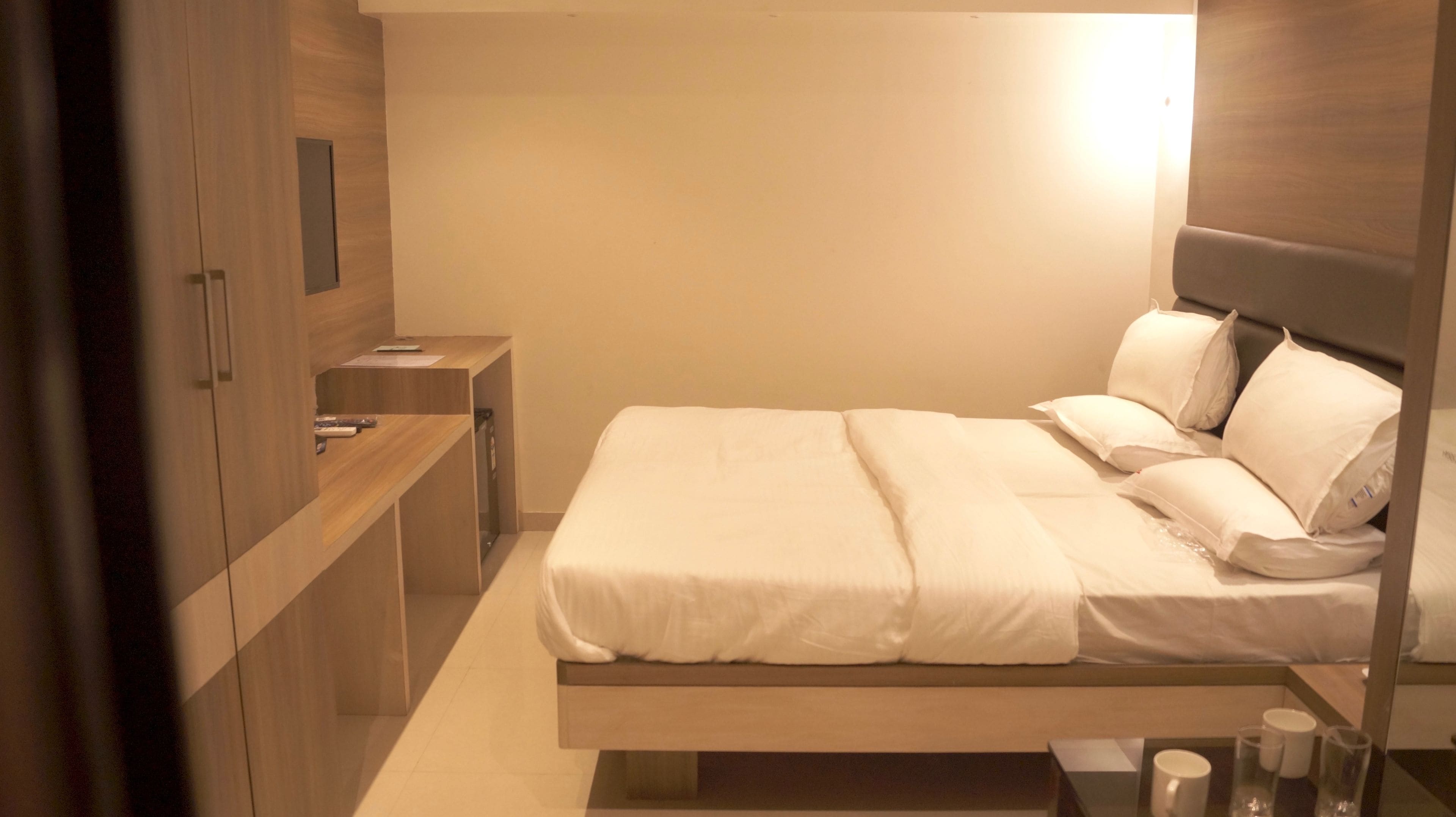 A modern bedroom with a bed, bedside tables, and a built-in wardrobe.