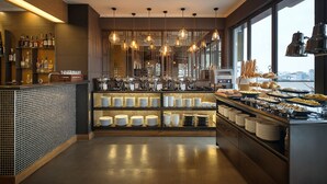 A modern bar area with a variety of bottles and glasses, a buffet with plates and bowls, and hanging pendant lights. - Bespoke Trendy Hotel Hanoi (Hanoi)