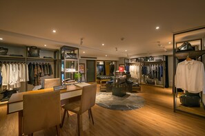 Un hall d’hôtel comprenant un comptoir d’accueil, un espace salon et des portants à vêtements.