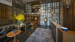 A modern hotel lobby with a seating area, a reception desk, and a staircase. - Bespoke Trendy Hotel Hanoi (Hanoi)