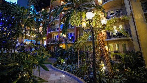 A multi-story hotel with balconies, indoor plants, and warm lighting. - L'Hôtel Québec par JARO (Québec City)