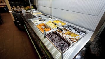 A buffet with various food items and utensils.