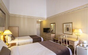 A hotel room with two beds, a desk with a chair, a television, and a coffee maker. - Auberge Québec (Québec City)