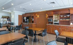 A restaurant with wooden furniture, a coffee station, and a microwave. - Auberge Québec (Québec City)