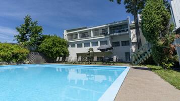 Una piscina al aire libre de temporada, sombrillas