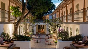 A courtyard with outdoor seating, a covered walkway, and potted plants.