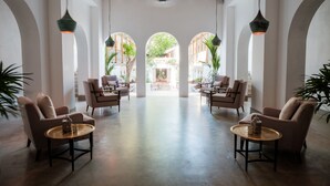 A spacious lobby with high ceilings, arched doorways, and modern lighting fixtures.