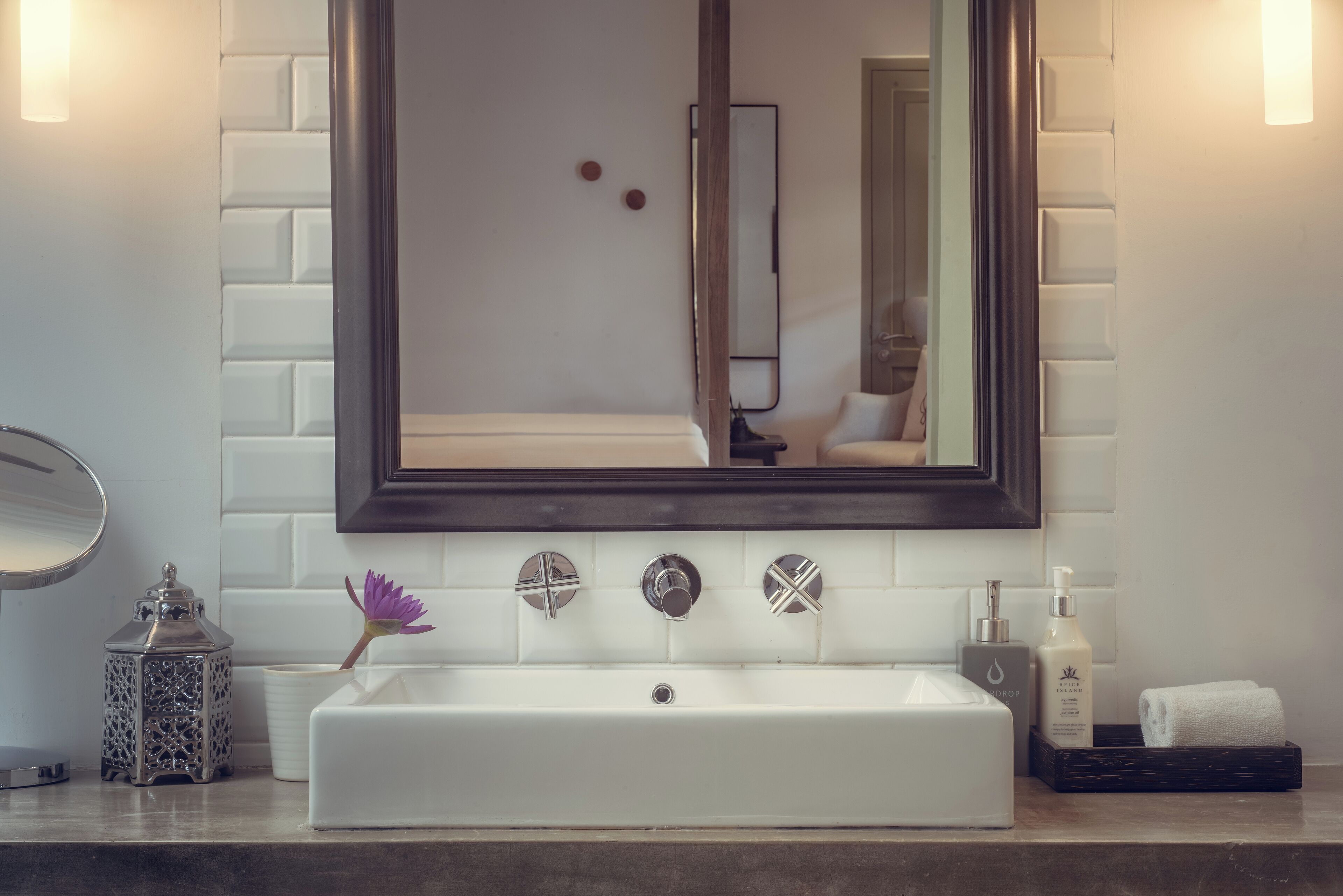 A bathroom with a white sink, a large mirror, and a dark wooden cabinet.