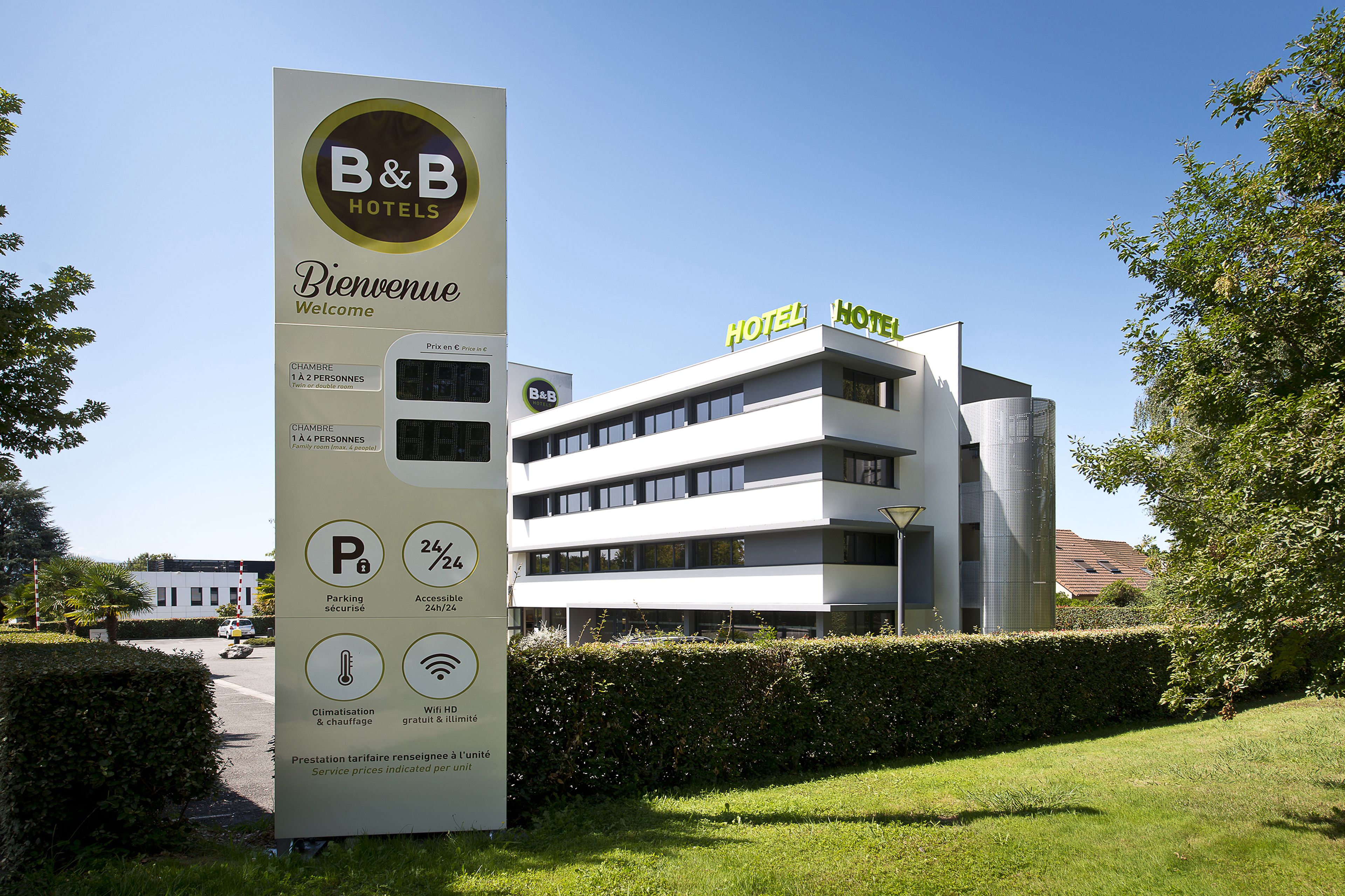 A B&B hotel with a modern design, a signboard with amenities, and a clear view of the building.