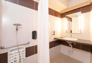 Un baño con ducha, lavamanos y espejo.
