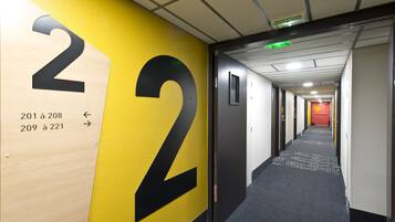 Un pasillo con un gran número 2 en la pared, que indica las habitaciones 201 a 221.