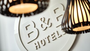 A B&B hotel sign with a circular design and a modern pendant light fixture. - B&B HOTEL La Rochelle Centre les Minimes (La Rochelle)