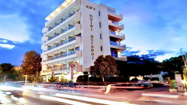 Un hotel de varios pisos con balcones y un letrero que dice "hotel acropoli".