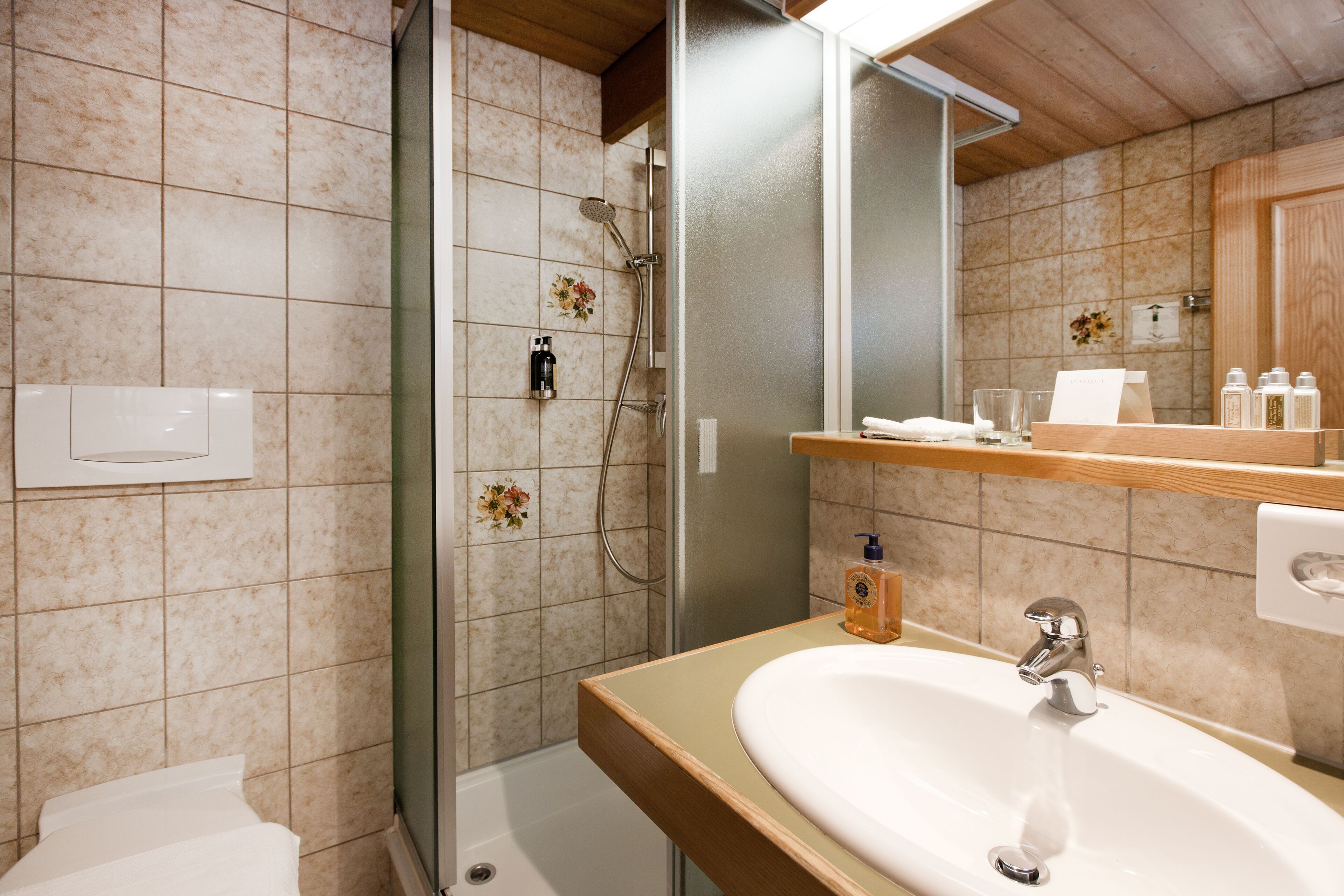 A bathroom with a shower, sink, and toilet.