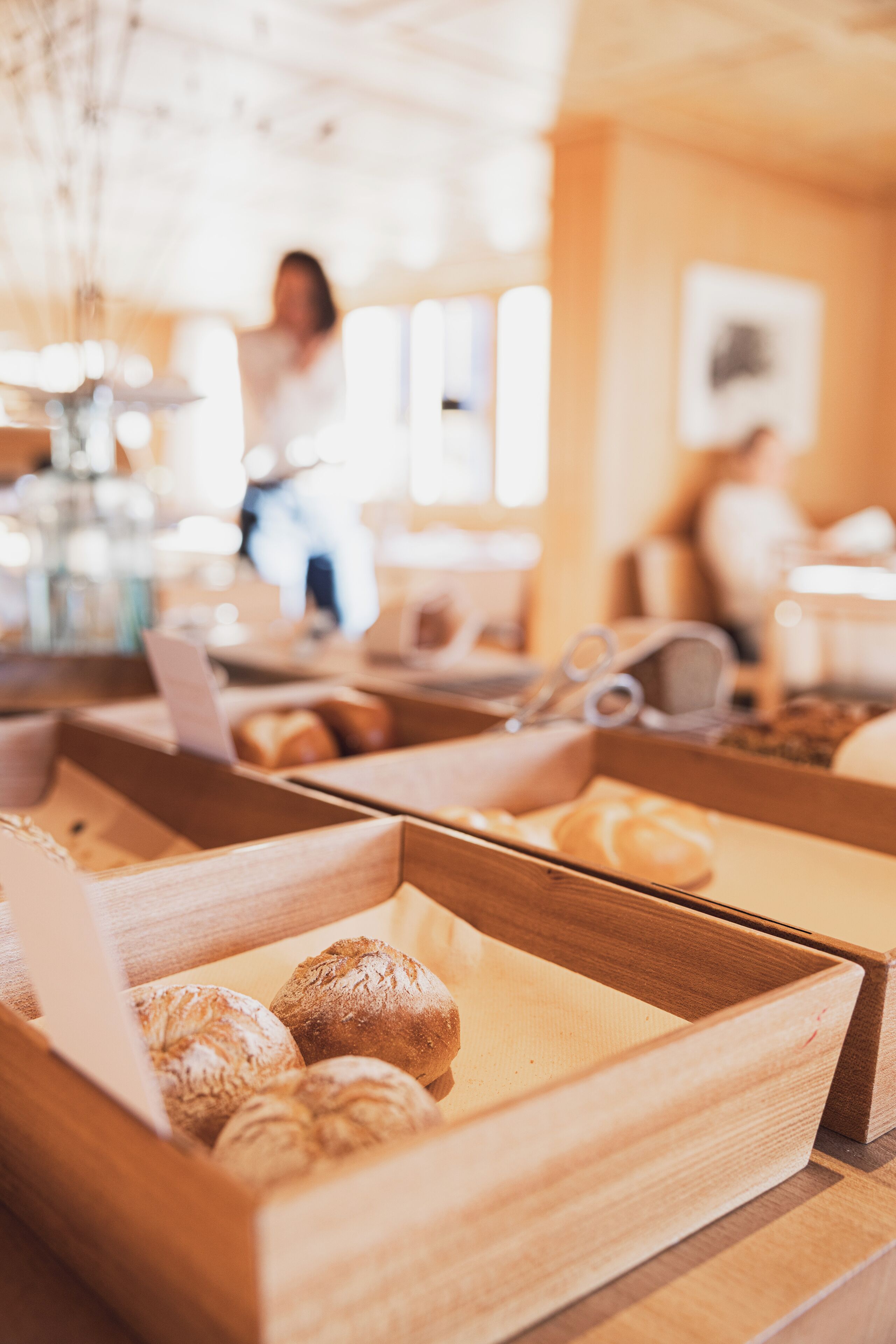 A bakery display with various baked goods in wooden boxes.