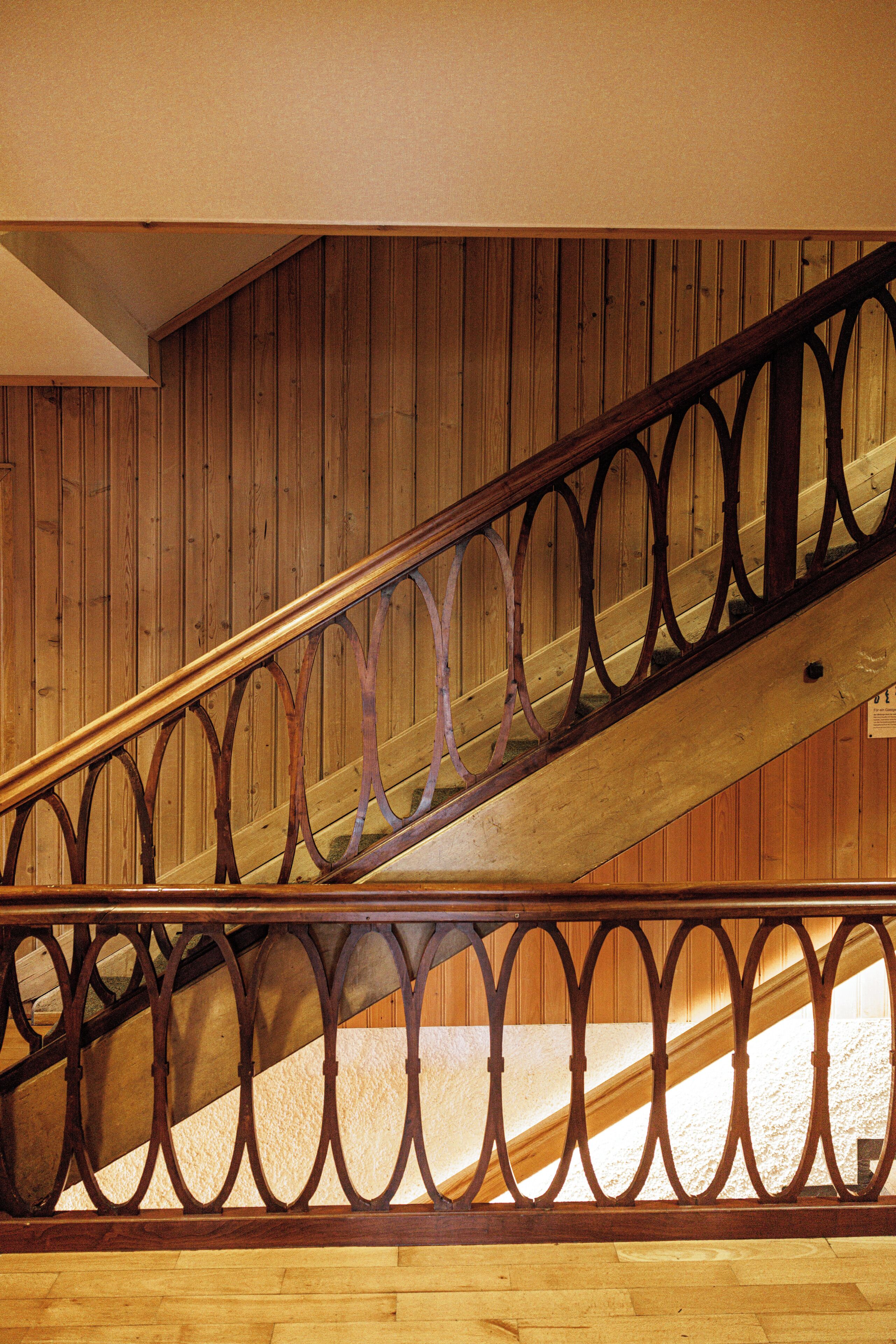 A wooden staircase with ornate metal railings.