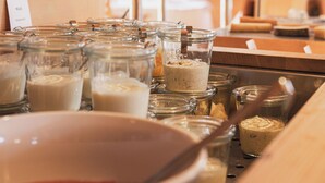 A kitchen area with glass jars containing various food items, a large mixing bowl, and a wooden counter. -  Krone Hittisau - Hotel & Restaurant im Bregenzerwald (Hittisau)