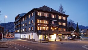 A multi-story hotel with a prominent sign reading "Wastof Haus." The building features a mix of brick and white exterior walls, multiple windows, and balconies. -  Krone Hittisau - Hotel & Restaurant im Bregenzerwald (Hittisau)