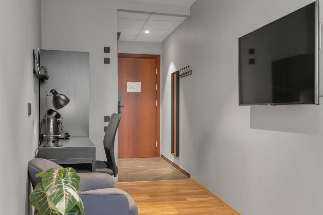 En hall med ett skrivbord, en stol och en tv som är monterad på väggen.