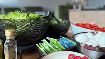 Una encimera de cocina con diversos alimentos, como lechuga, rábanos, huevos y una botella de aceite.