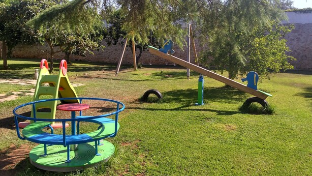A playground with a seesaw, a merry-go-round, and a tire swing. - Agriturismo Masseria Nuova (Francavilla Fontana)
