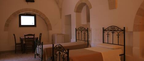 A room with two beds, a table, and chairs.