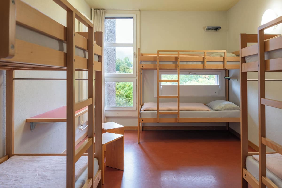 Un dormitorio con literas, una ventana y un escritorio.